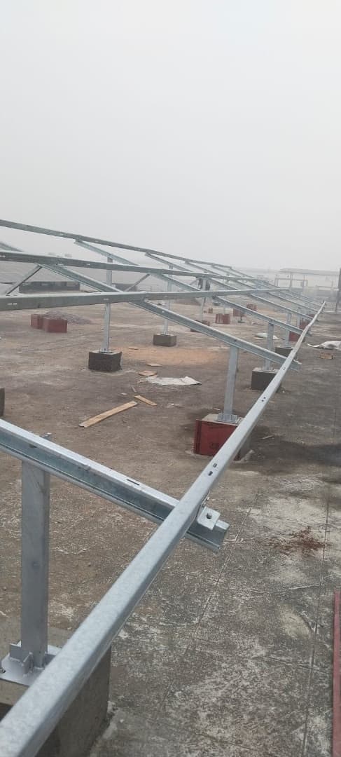 Galvanised steel mounting rails on concrete footings across a flat roof before solar panels are fitted